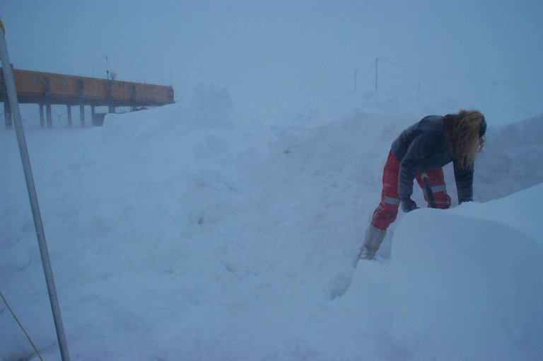 Cat Gillies digging snow for the melt tank in a blow